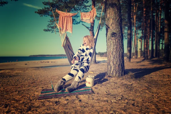 Vrouw in koe pyjama's in een hangmat — Stockfoto