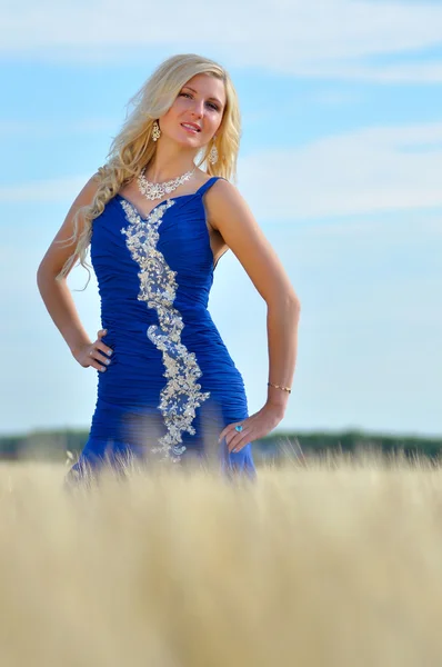 Szczęśliwa kobieta w niebieską sukienkę w złotej pszenicy — Zdjęcie stockowe