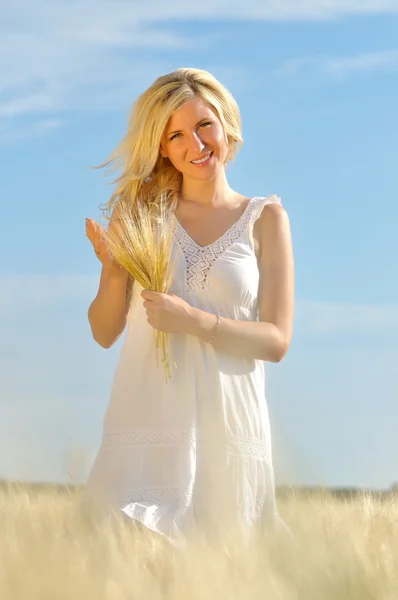 Glückliche Frau posiert im goldenen Weizen. — Stockfoto