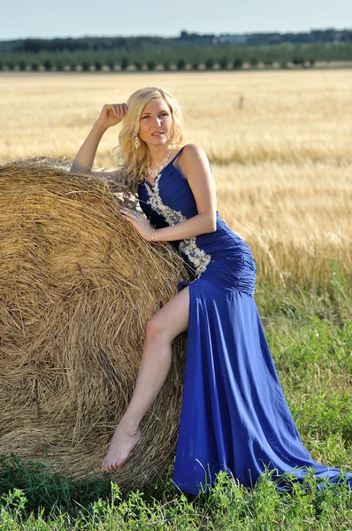 Glückliche Frau in blauem Kleid in goldenem Weizen — Stockfoto