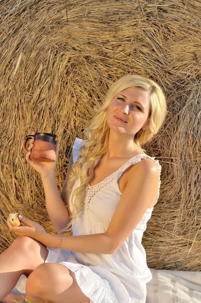 Happy woman posing with bread, milk and hay — Stock Photo, Image
