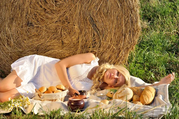 Mulher feliz posando com pão, leite e feno — Fotografia de Stock