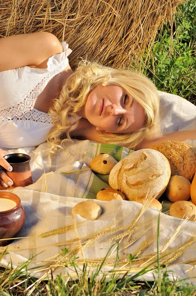 Mulher feliz posando com pão, leite e feno — Fotografia de Stock