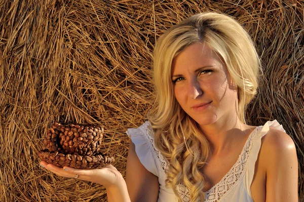 Glückliche Frau posiert mit Brot, Kaffeetasse und Heu — Stockfoto