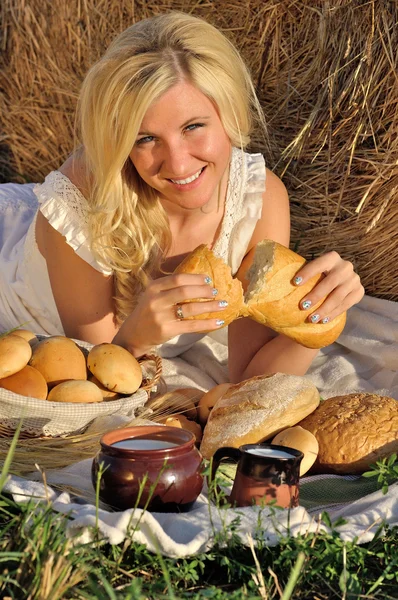 Happy woman posing with bread, milk and hay — Stock Photo, Image