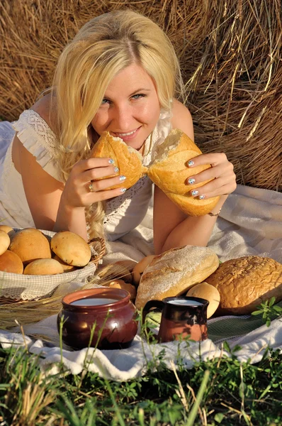 Happy woman posing with bread, milk and hay — Stock Photo, Image