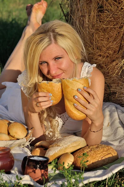 Mulher feliz posando com pão, leite e feno — Fotografia de Stock