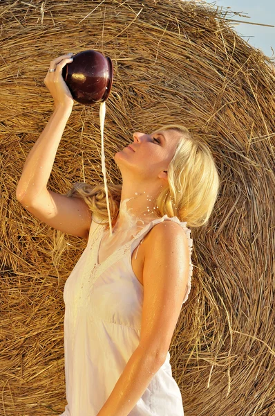 Mujer feliz bebiendo leche de la vasija o la vasija —  Fotos de Stock