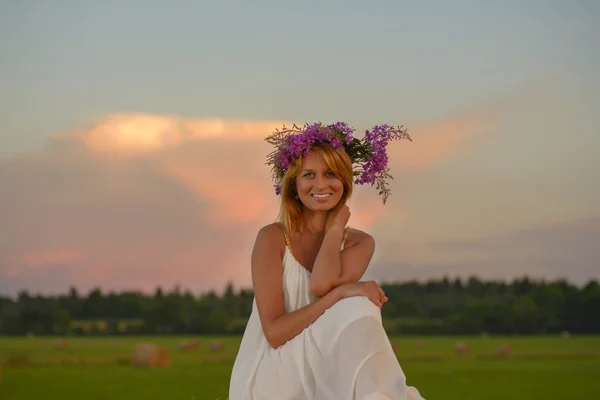 Donna bionda in posa al tramonto su un campo — Foto Stock