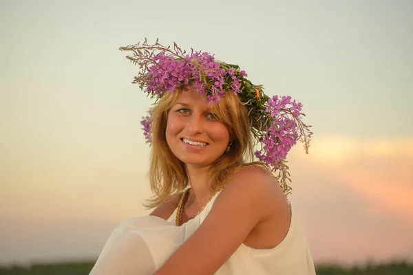 Blonde vrouw die zich voordeed op zonsondergang tijd op een veld — Stockfoto