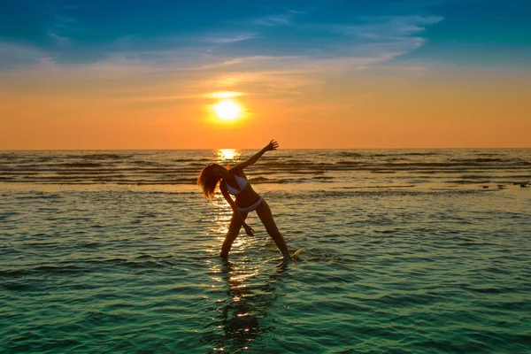 Vrouw in witte bikini poseren in een zee — Stockfoto