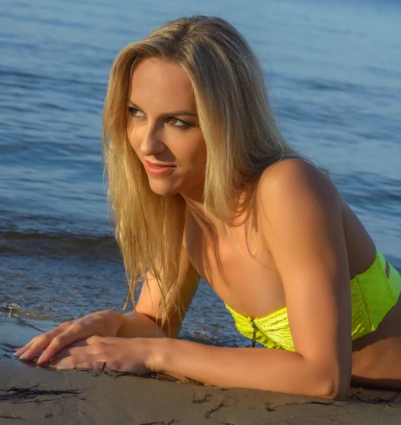 Mujer joven en bikini verde posando en una playa — Foto de Stock