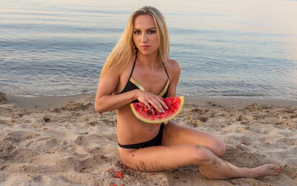 Gelukkig meisje in zwarte bikini ontspannen op het zand — Stockfoto