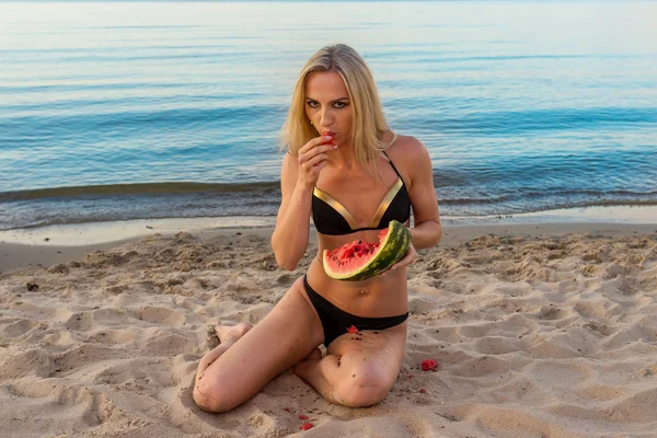 Menina feliz em biquíni preto relaxante na areia — Fotografia de Stock