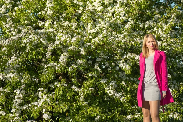 Joven mujer hermosa en un jardín floreciente — Foto de Stock