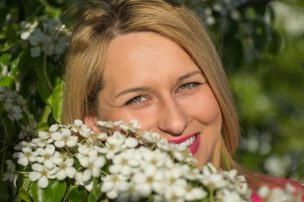 Vacker kvinna i rosa jacka i blommande trädgårdar — Stockfoto