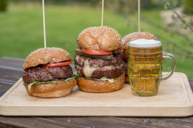 Lezzetli ızgara burger ve bardak soğuk bira.