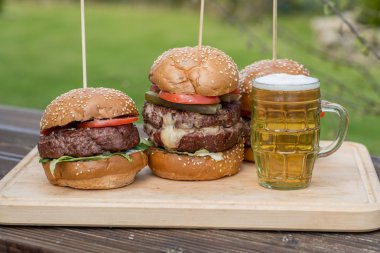 Lezzetli ızgara burger ve bardak soğuk bira.