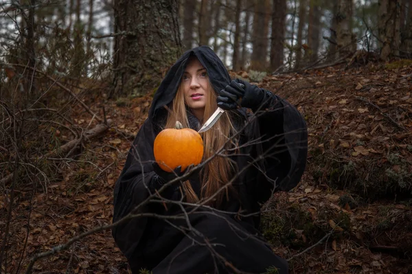 Vrouw met pompoen in bos — Stockfoto