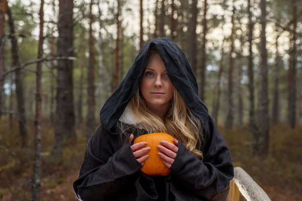 Frau mit Kürbis im Wald Stockbild