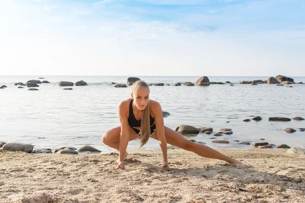 Young beautiful girl athlete on the beach in summer — Stock Photo, Image