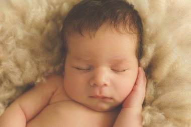    Bej arka plandaki bebek tatlı tatlı uyuyor.