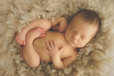    Bej arka plandaki bebek tatlı tatlı uyuyor.