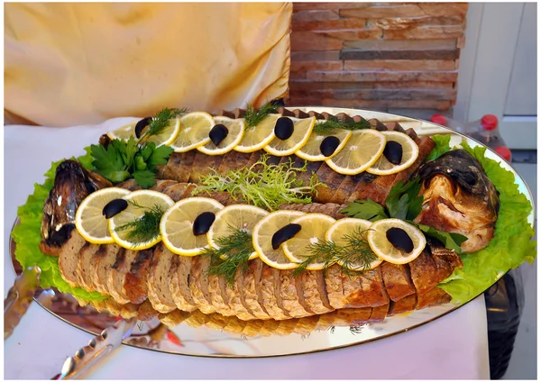 The stuffed fish on a dish is decorated with a lemon — Stock Image The stuffed fish on a dish is decorated with a lemon Royalty Free Stock Images
