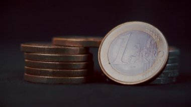 Avro sikkeleri, arka plandaki karanlık çekime karşı. Makro mercekle çekilmiş. Sığ alan derinliği