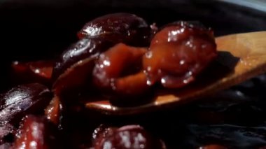 Erik reçeli pişirilir ve ahşap kaşıkla karıştırılır. Sığ alan derinliği