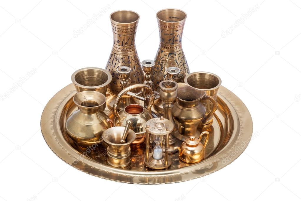 Set of decorative souvenirs from copper and bronze on a tray 