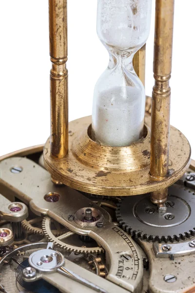 Hourglass standing on the open clockwork of a pocket watch — Stock Photo, Image