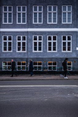 Bazı insanlar Kopenhag, Danimarka, Kuzey Avrupa 'da bir binanın önünde yürüyorlar.