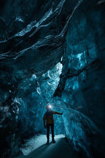 Explorer in the blue ice caves in Jokulsarlon glacier, Iceland, North Atlantic Ocean