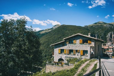 Katalonya, İspanya 'da küçük ve kırsal bir kasaba manzarası. Evlerin cepheleri eski taştan yapılmış ve bütün evler birbirine çok benziyor. Görüntü güneşli bir günde çok az bulutla yapılır..