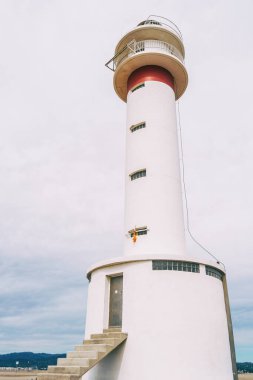 lighthouse on the lonely beach of delta del ebro, tarragona, spain. The day is cloudy and windy.