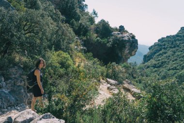 Tarragona, İspanya 'daki Prades Dağı' nda küçük bir patika boyunca yürüyen bir kız. Güneşli bir yaz gününde