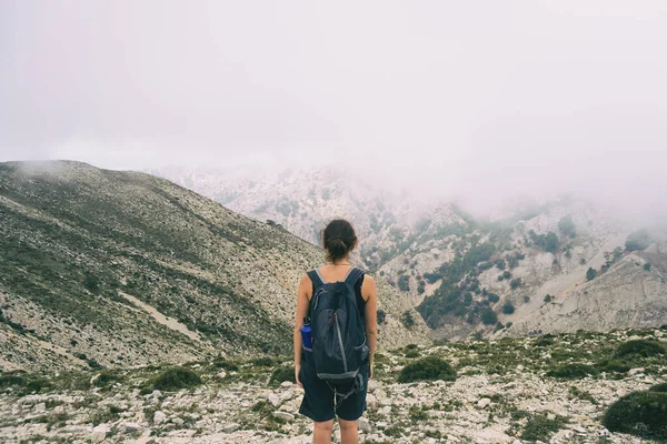 woman hiking on a mountain path in catalonia on a cloudy summer day