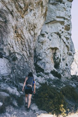 Bulutlu bir yaz gününde Katalonya 'da dağ yolunda yürüyüş yapan bir kadın.
