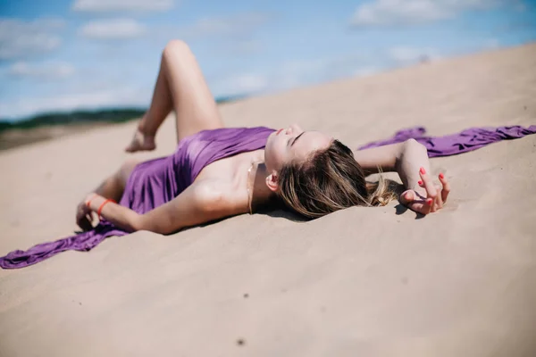 若いです,紫の布のポーズを持つスレンダーな女の子砂漠で — ストック写真