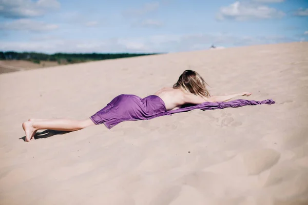 Mladá, štíhlá dívka s purpurovým hadříkem pózuje v poušti — Stock fotografie