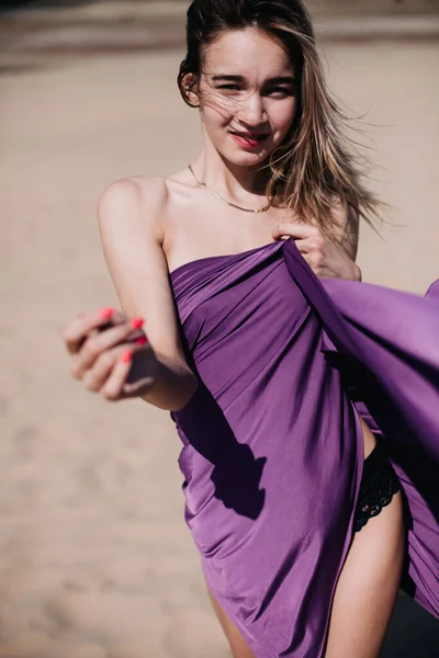 Tineri, fată zveltă cu pânză violet pozează în deșert — Fotografie, imagine de stoc