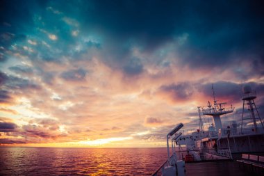 Feribot gün batımında denizin üzerinden geçiyor.