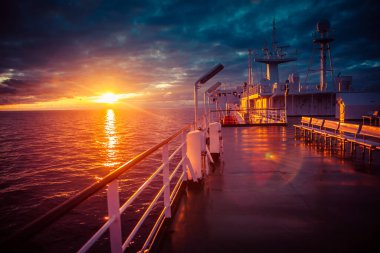 Feribot gün batımında denizin üzerinden geçiyor.