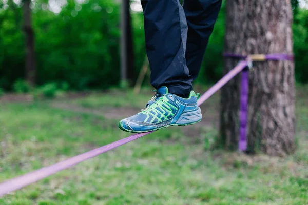 Young man balancing and jumping on slackline. — Stock Photo, Image