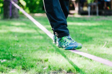 Genç adam dengede duruyor ve ip üzerinde zıplıyor.. 