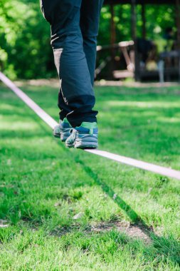 Genç adam dengede duruyor ve ip üzerinde zıplıyor.. 