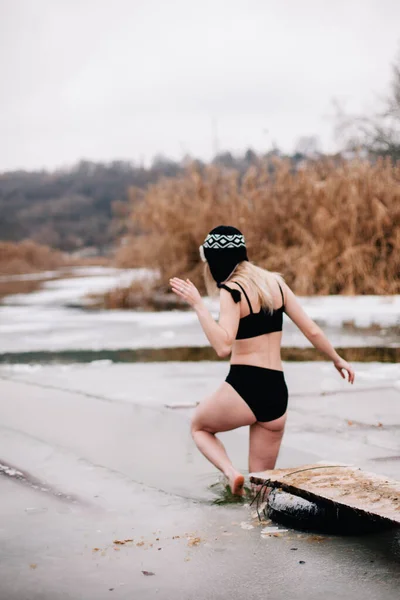 Joven esbelta chica se baña en invierno en un agujero del río — Foto de Stock