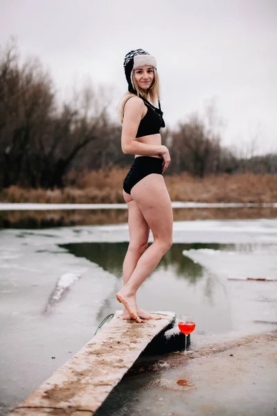 Jong slank meisje baadt in de winter in een rivier gat — Stockfoto