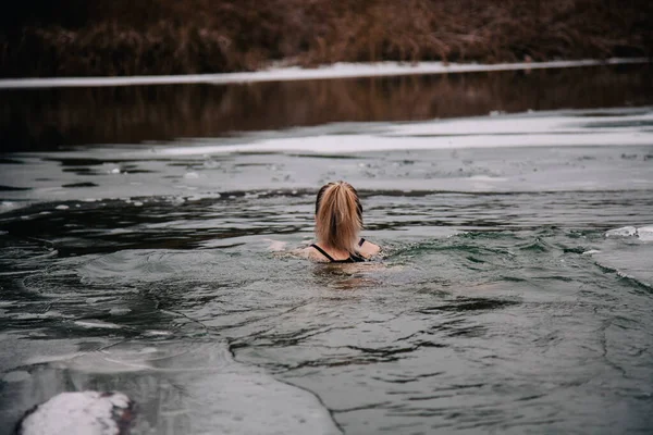 Joven esbelta chica se baña en invierno en un agujero del río — Foto de Stock